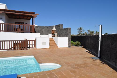 普拉亚布兰卡Villa Esmeralda的一个带游泳池和房子的后院