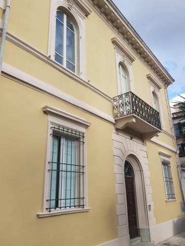 比萨PALACE COMFORT INN的黄色的房子,设有阳台和门