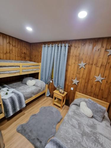 科维良Serra da Estrela Guest House的木镶板客房内的两张床