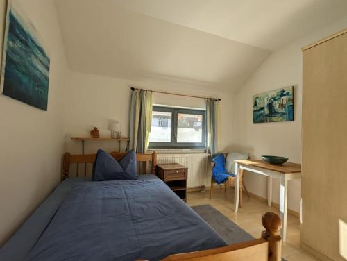 欣特察尔滕Ferienhaus Ketterer Hinterzarten的一间卧室配有一张床、一张书桌和一个窗户。