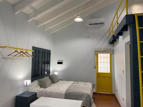 门多萨Departamento Excelente Ubicación. Zona Arístides y Parque.的一间卧室设有一张床和一个黄色的门