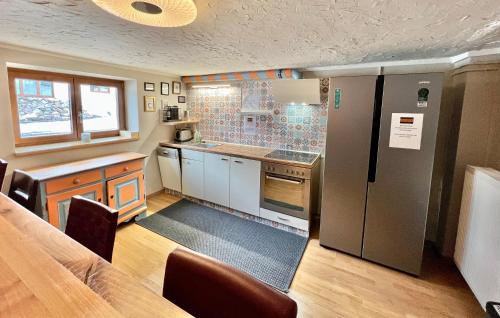莱赫阿尔贝格Lech Hostel的厨房配有不锈钢冰箱和桌子