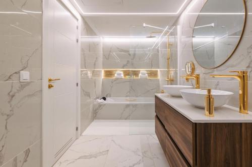 波多黎各Grand Horizon Luxury Boutique Apartments的浴室设有2个水槽、浴缸和镜子
