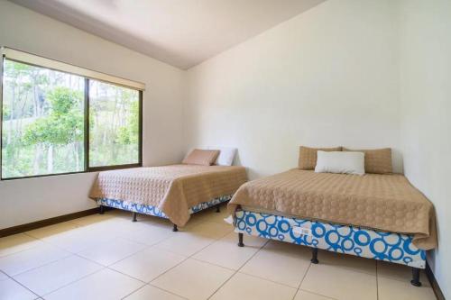 图里亚尔瓦Rancho Bellavista, Unique views, Pool and WiFI!的一间卧室设有两张床和窗户。