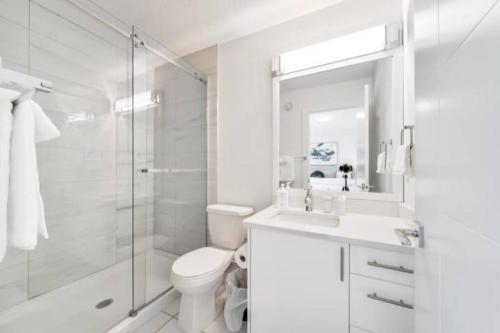 埃德蒙顿✦Chic Haven✦3BR Near DT & WEM, King Bed, Trails, Fast Wifi, Sleeps 6!的白色的浴室设有卫生间和淋浴。