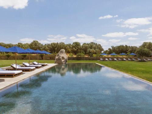 蒙萨拉什圣洛伦索巴洛卡酒店的一个带躺椅和蓝伞的游泳池