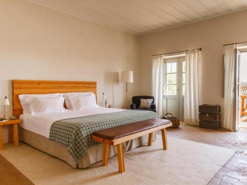 蒙萨拉什圣洛伦索巴洛卡酒店的一间卧室配有一张床、一把椅子和窗户。
