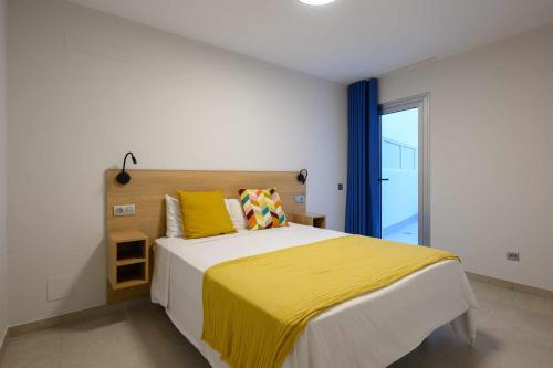 大加那利岛拉斯帕尔马斯Canteras Urban Beach的一间卧室配有一张带黄色毯子的大床