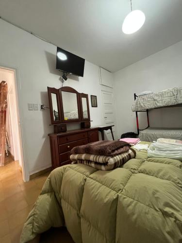 科斯金Casa de Tati en Cosquín Córdoba的一间卧室配有一张床、梳妆台和镜子