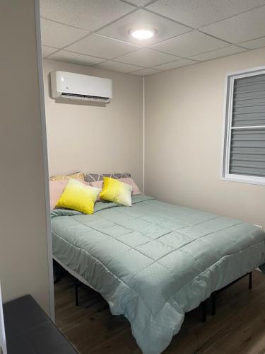 SabanaCasitas at Flambohio Beach Camp的一间卧室配有一张带黄色和粉红色枕头的床