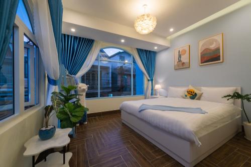 大叻Moc Thach Blue House DaLat的一间卧室配有一张带蓝色窗帘的床和一扇窗户