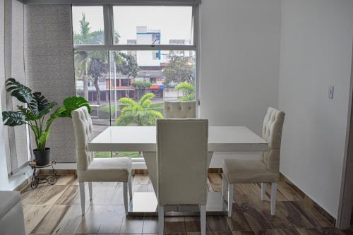 佩雷拉Acogedor Apartamento, excelente ubicación. Pereira的白色的用餐室配有白色的桌椅