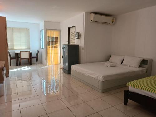 曼谷OYO 75417 Grandview Condominia的一间卧室配有一张床、一间厨房和一张桌子