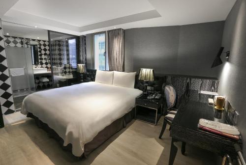 台北雀客旅馆台北站前的一间带白色大床的卧室和一间浴室