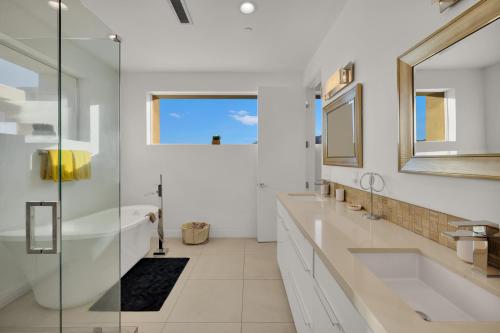棕榈泉Breathtaking Luxury Villa Architectural Jewel的浴室设有2个水槽、浴缸和镜子