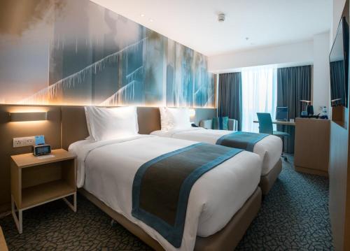 马尼拉Holiday Inn Express Manila Newport City, an IHG Hotel的酒店客房配有两张床和一张书桌