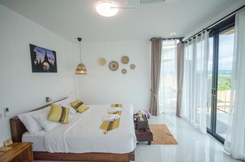 Ban Pha Saeng LangCaligo Resort的白色的卧室设有床和大窗户