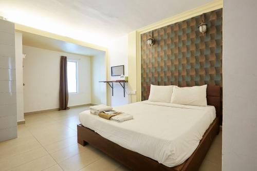 关丹Mawar Villa, Batu Hitam的一间卧室配有一张带白色床单的大床