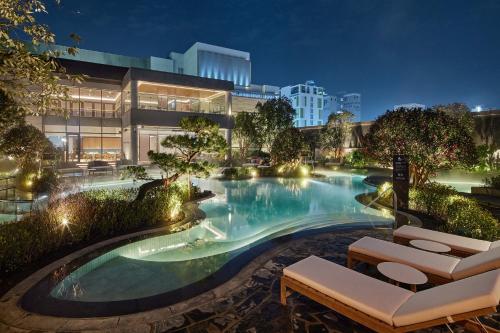 釜山釜山乐天酒店的一座游泳池,在晚上在建筑物前