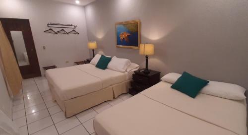 马塔加尔帕Hotel San Jose, Matagalpa.的酒店客房,设有两张床和一张沙发