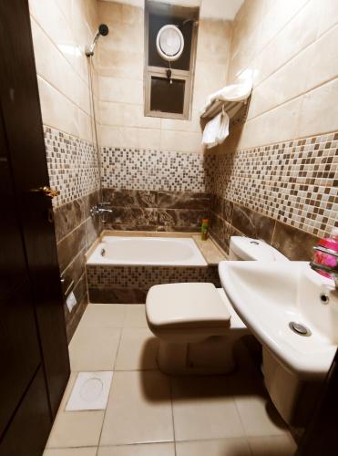 瓦迪穆萨noor apartment的浴室配有卫生间、盥洗盆和浴缸。