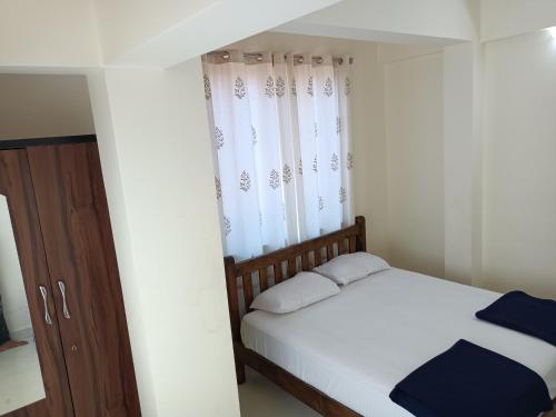 达波林Sai Leela Guest House的一间小卧室,配有床和窗户