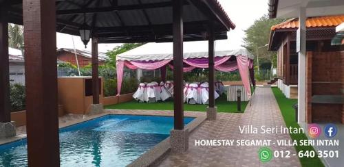 昔加末Homestay Segamat - Villa Seri Intan的游泳池畔帐篷下的婚宴