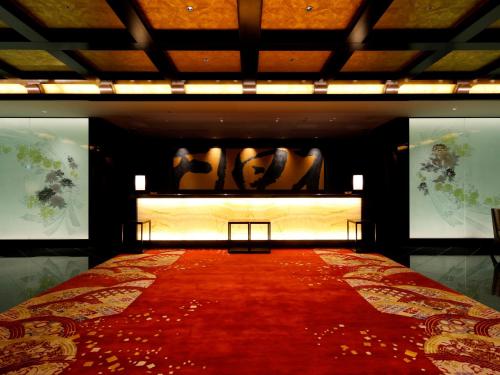 金泽金泽山乐酒店的房间里的床上铺有红地毯