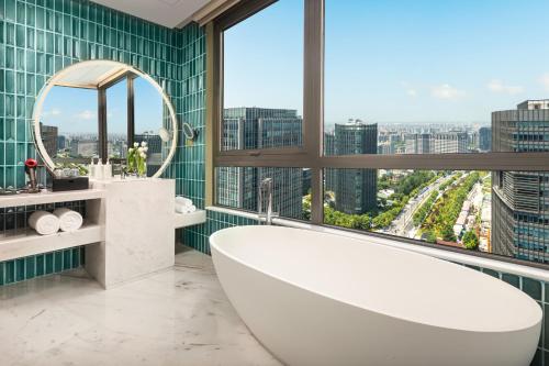 上海上海大华长风华邑酒店的带浴缸的浴室和大窗户