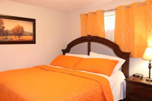 阿伯茨福德2-Bedroom basement suite with a separate entrance.的一间卧室配有橙色的床和窗户。