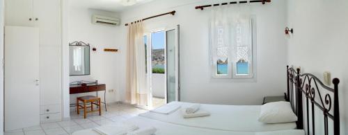 普拉提伊亚洛斯西弗诺斯LEANDROS APARTMENTS的一间卧室设有两张白色的床和窗户