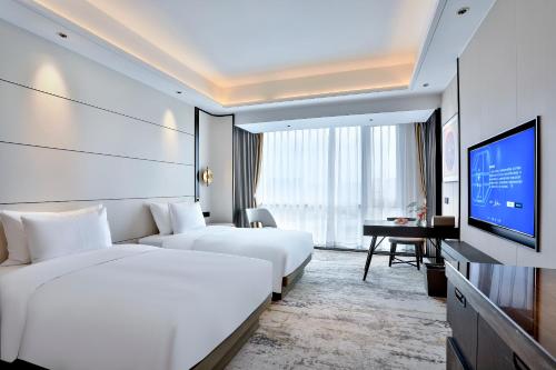 义乌银都酒店 Yandoo Hotel的酒店客房设有两张床和一台平面电视。