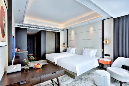 义乌银都酒店 Yandoo Hotel的酒店客房配有两张床和一张书桌