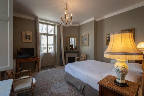 布尔日L'Hotel de Panette, chambres indépendantes - entrée sainte Chapelle的一间卧室配有一张床和一张桌子上的台灯
