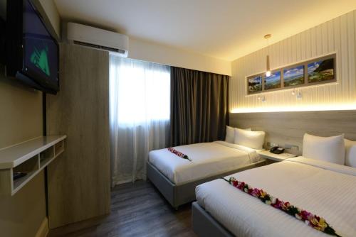 塔穆宁关岛温德姆花园酒店的酒店客房设有两张床和一台平面电视。