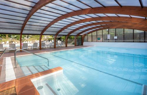 艾克塞恩维克斯Camping La Pinède的一个带开放式天花板的大型游泳池