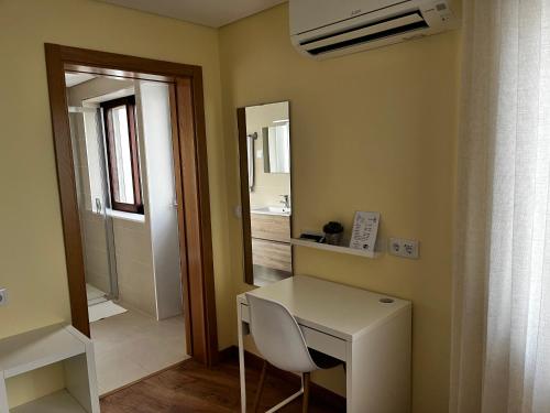 瓜尔达Aliança Alojamento Local的一间设有白色书桌和镜子的客房