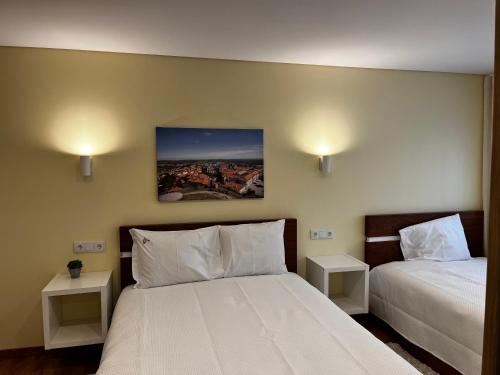 瓜尔达Aliança Alojamento Local的一间卧室配有两张床和两个床头柜。