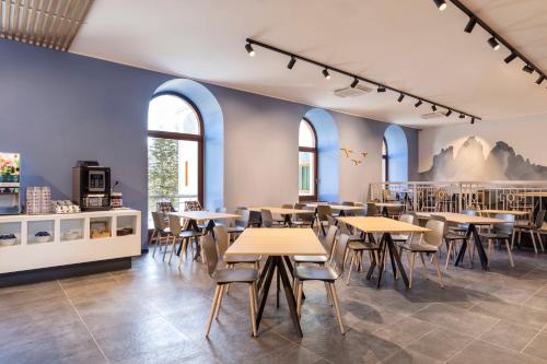 科尔蒂纳丹佩佐B&B Hotel Passo Tre Croci Cortina的餐厅设有桌椅和窗户。