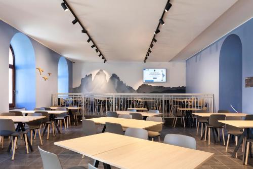 科尔蒂纳丹佩佐B&B Hotel Passo Tre Croci Cortina的一间带桌椅和屏幕的用餐室