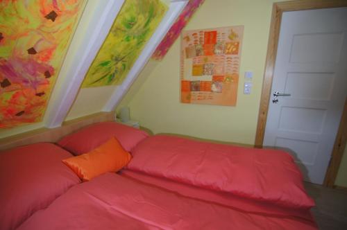 兰图姆Mini Beach House II的客房内的红色沙发,配有橙色枕头