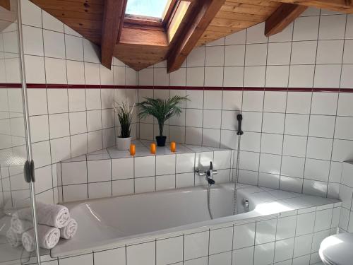 Comoretthe Jad B&B的浴室设有白色浴缸,拥有木制天花板