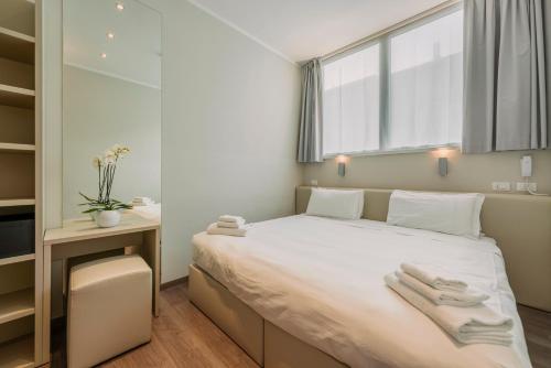 塞格拉泰Fasthotel Linate的一间卧室配有一张大床和毛巾