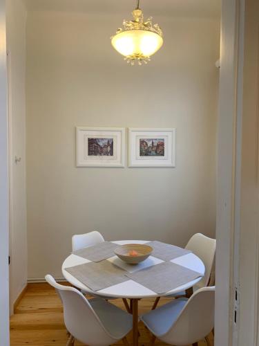沃洛斯Anavros beach house的餐桌、白色椅子和吊灯
