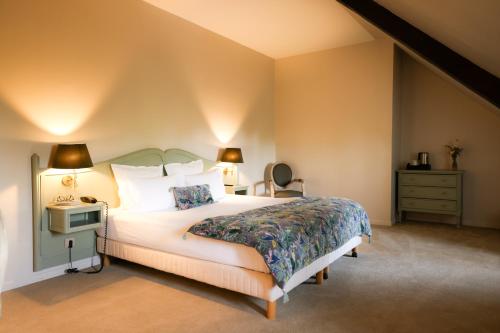 奥内莱沙托Château de Fontanges的一间卧室配有一张床、梳妆台和灯具。