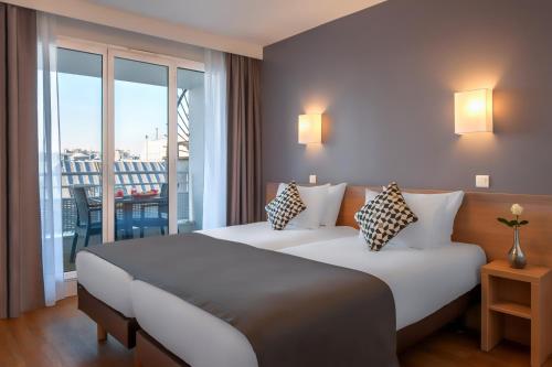 巴黎馨乐庭巴黎马莱巴士底狱酒店的酒店客房设有两张床和一个阳台。