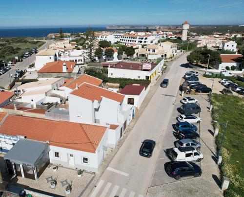 萨格里什Casa Sagres T2 - 3 minutos a pé Praia da Mareta的一条城市街道,有汽车停在停车场