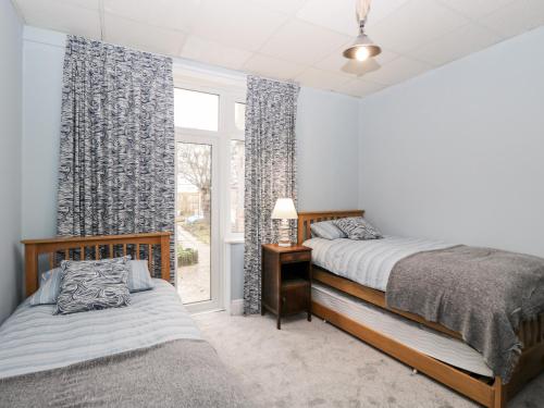 伯恩茅斯Molly's Place的一间卧室设有两张床和窗户。