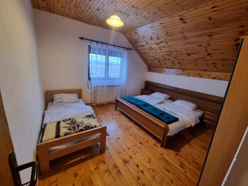 扎布利亚克Apartments Đurđić的配有木天花板的客房内的两张床