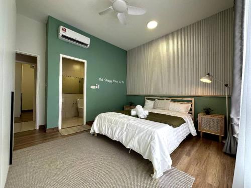 马六甲The Apple PREMIER CONDO three bedroom in MELAKA的一间卧室设有一张大床和绿色的墙壁
